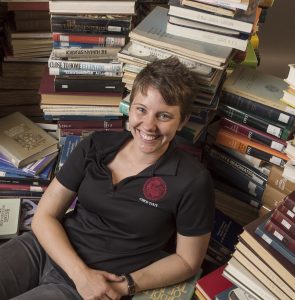 PA staff Kate Post has her portrait taken in the midst of 1000 books as part of the new faculty portraits photographed in the studio on Wednesday, August 16, 2017 in Chico, Calif. 